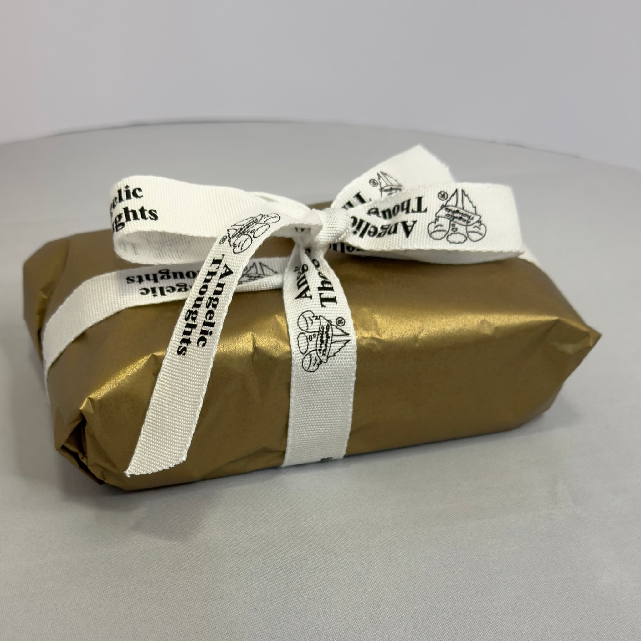 2 pack tealight wrapped in gold tissue paper and tied with angelic thoughts ribbon