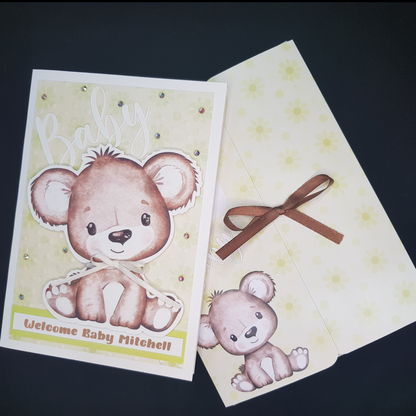 Picture of the baby brown bear card and a folder. Folder has image of small baby bear, scattered green polka dots and a brown ribbon tie to keep folder closed.