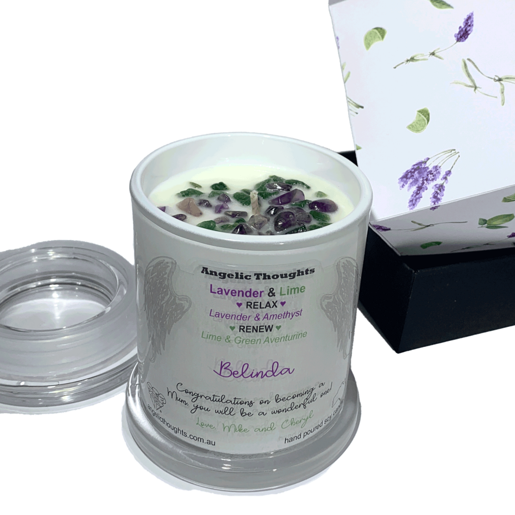 elevated front on view of lavender and lime scented soy candle featuring amethyst and green aventuring crystels. The container has a personalised label and the lid is off. The product boxes are on the right side