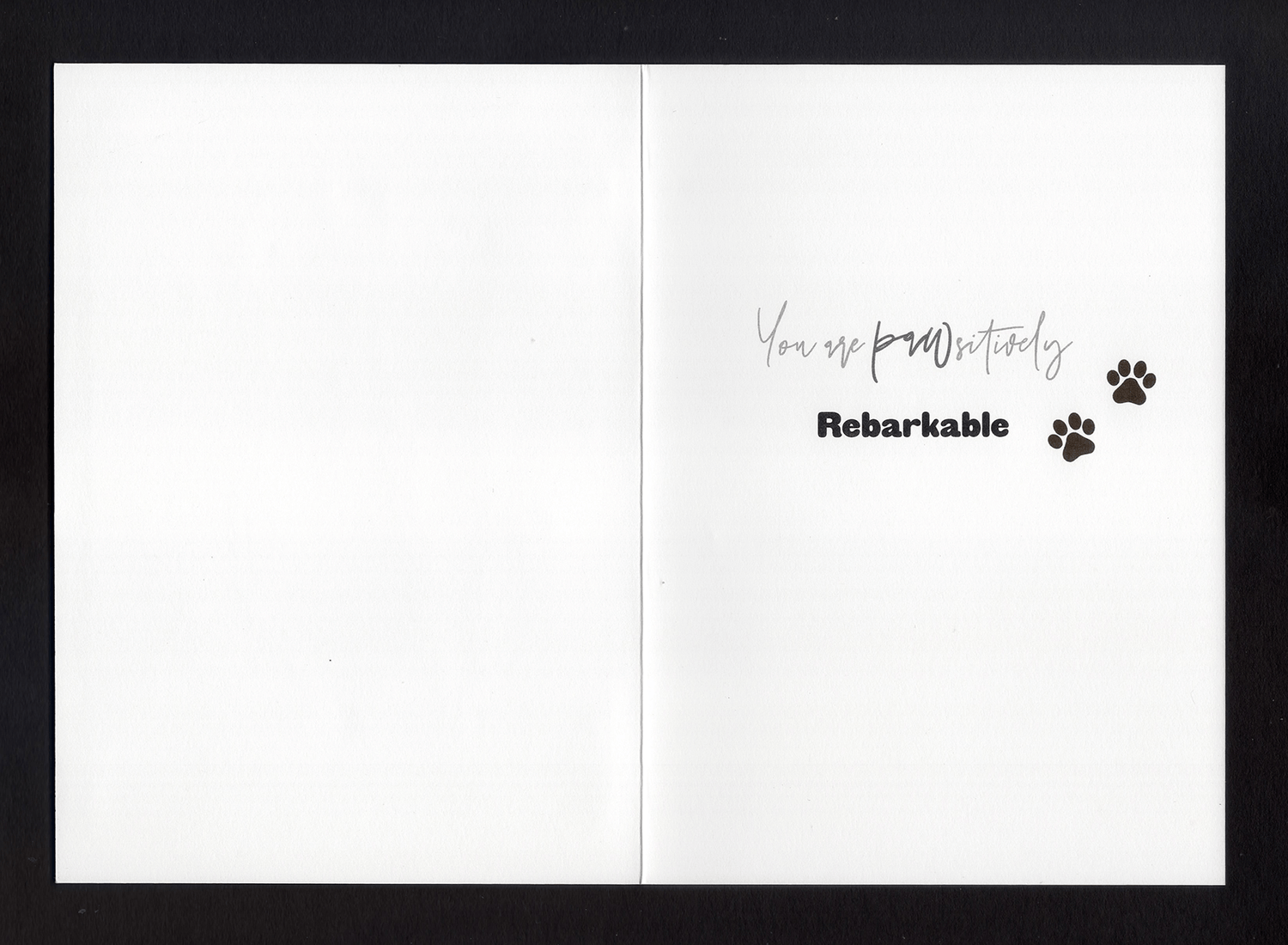 An open card with the words &quot;You are pawsitively rebarkable&quot; and two paw prints 