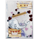 Handmade card featuring a raised cutout whale on a wooden box with heart banner and the customisable name of the recipient. It is fully enclosed in a shaker pocket with irridescent and red hearts of varying sizes and blue glitter.
